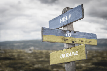 help to ukraine text quote on wooden signpost outdoors, written on the ukranian flag.