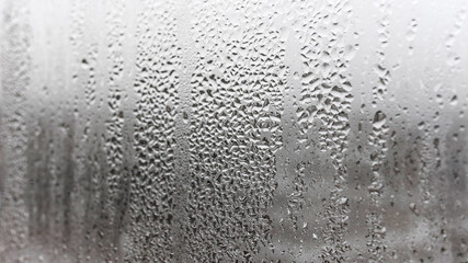 Texture condensation on the glass, outside, bad weather, rain. Steamy window with water drops made in dull day