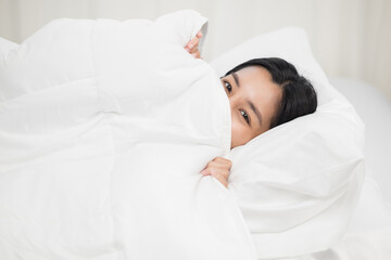 Beautiful asian woman lying in the bed . Young woman sleeping well in comfortable cozy fresh bed on soft pillow white linen. Morning in the bedroom. Health and rest concept.