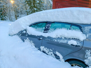 Parked car in the snow after a snowfall. Winter operation and storage of vehicles