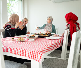 Muslim family and friends gathering together at home for eating dinner. High quality photo