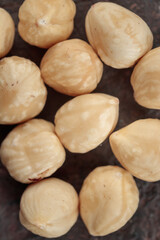 Peeled hazelnuts top view on a dark background