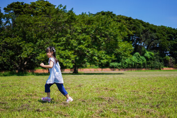 Fototapeta premium 外で走り回る小さな女の子