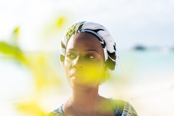 Beautiful dark skin young woman between palm branches on beach photo