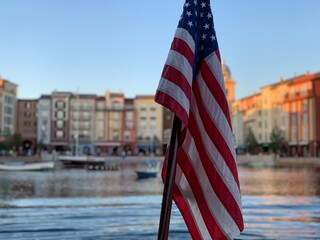 american or usa flag with river and city buildings on the back in orlando florida.