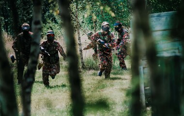 Group of people playing paintball - obrazy, fototapety, plakaty