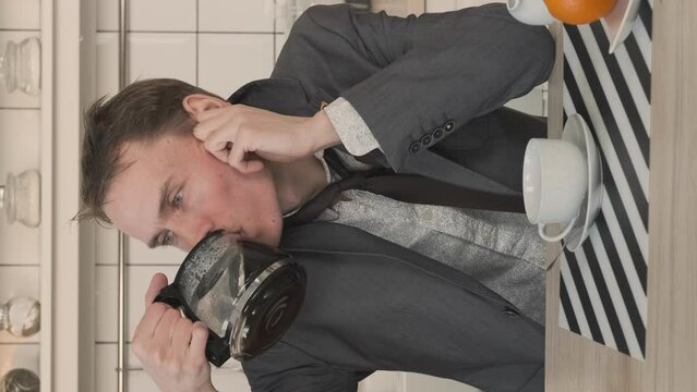 Vertical Video. Haggard Entrepreneur Drinking Coffee in the Kitchen. Man Looks Disheveled and Untidy after Sleepless Night