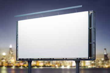 Blank white billboard on city buildings background at night, perspective view. Mockup, advertising concept