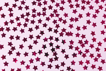 Kraft paper gift box with pink ribbon bow on pink background with confetti. Christmas present, valentine day surprise, birthday concept. Flat lay, top view. High quality photo