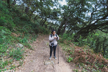 Chica joven guapa con cámara de fotos en ruta de sendero verde por la sierra de la sauceda 