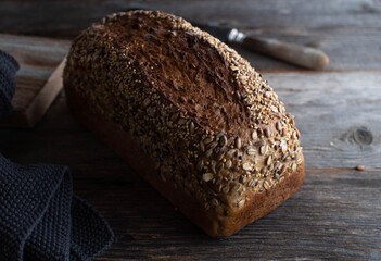 Loaf of whole wheat bread with seeds on a table