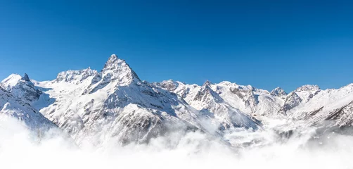 Fotobehang Panoramic view of winter snowy mountains in Caucasus region in Russia with blue sky © SDF_QWE