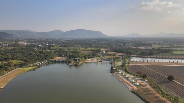 Aerial Footage of a Lake and Hotel Resort in Thailand with Beautiful Surrounding Landscape.