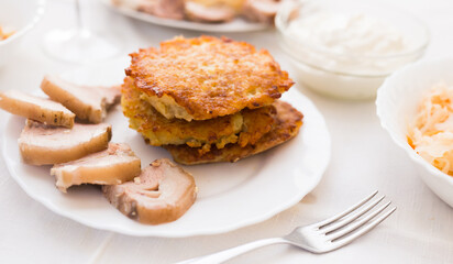 Potato pancakes with meat on white plate