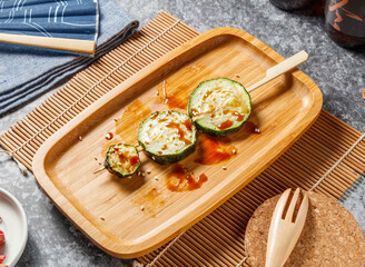 Pieces of melon love sticks in wooden dish isolated mate and grey background top view