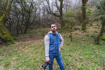 Chico joven  con cámara de fotos realizando senderismo por sierra andaluza