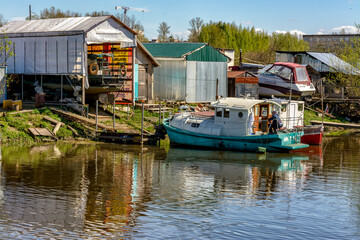 Fototapeta na wymiar Sunny may day on the banks of the Izhora river. Abandoned boats and boats.