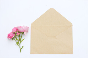 Feminine wedding still life composition. Mock-up scene with blank paper card and pink rose. Flat lay, top view, copy space.