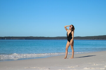 portrait of young woman in black bikini on the beach