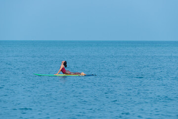 Asian yoga girl doing flexibility yoga exercise yoga on Sub-broad in sea. 