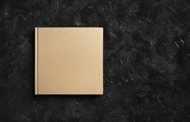 Blank closed book on black stone background. Responsive design template. Copy space for text. Flat lay.