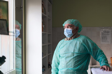Fototapeta na wymiar Mature confident doctor standing in front of surgery room - focus on the face