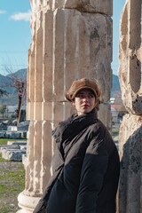 Young tourist woman travels ancient city.  She wears hat. She is exploring new places.