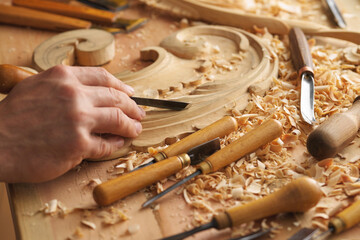 Wood carving, master's hands work with a wooden surface, a professional does wood crafts