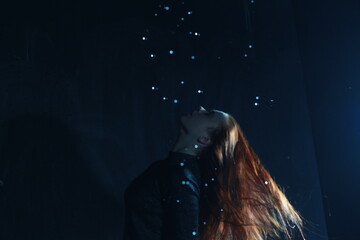Young woman in the water person rain black night fantasy abstract model fashion style beauty red hair female girl dance