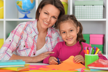 Fototapeta premium Mother teaches her cute daughter to do craft items