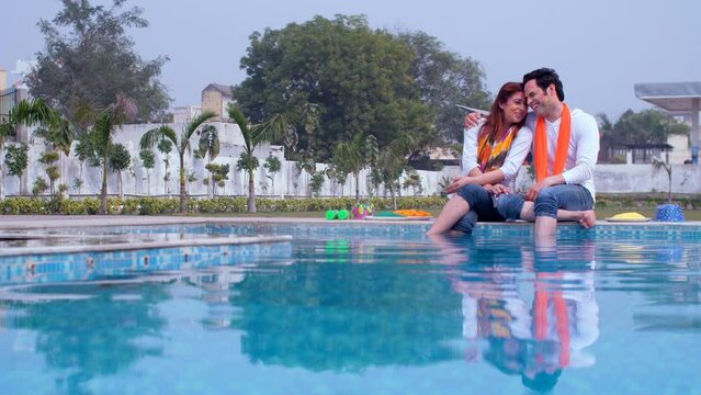 An attractive male and female with their faces covered in Holi colors talking to each other - best friends  organic Gulal  a Hindu festival. A romantic couple in traditional attire hugging each oth...