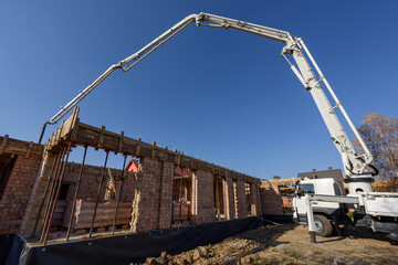 Truck mounted concrete pump at a construction site. Builder is pouring concrete into a wooden formwork. Private house construction.
Element of the unfolded hydraulic boom of the construction machine.