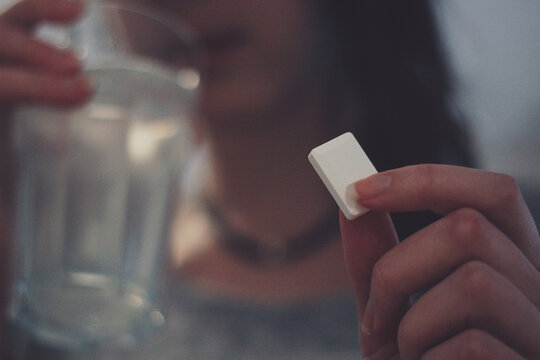 Woman eating sugar and drinking water to treat a sugar low (hypo)