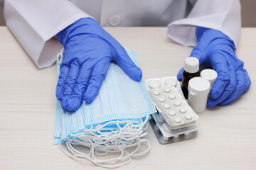 Medical masks and medicines in the hands of a doctor.