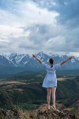 Woman in blue dress in summer Altai mountains in Kurai steppe