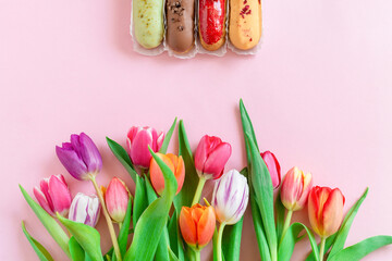 Colorful tulips and Eclairs is a traditional French pastry pink background . Love, Mother's day, Women's day and spring time flower background. spring nature background.