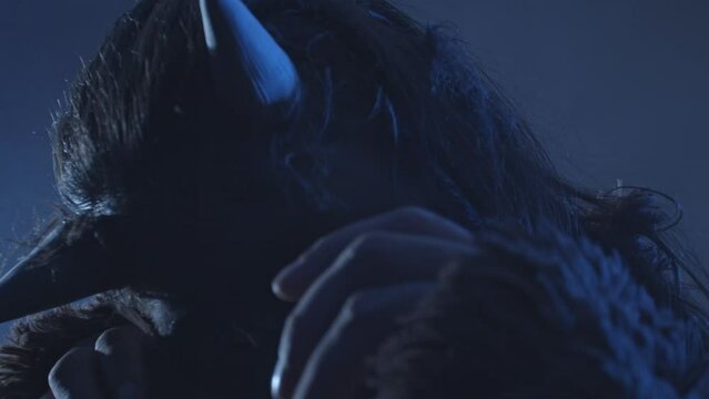 The horned devil covers his face with his hands. The personification of fear and terror. Screen adaptation of folk legends about evil spirits and demons. Art and performance