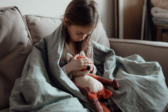 Stop War. Pray For Ukraine. We Stand With Ukraine. Ukrainian Frightened Child Under A Blanket. The Girl Is Afraid Of The Sounds Of Air Raids And Explosions. Poor Child Feeling Sorrow And Sadness.