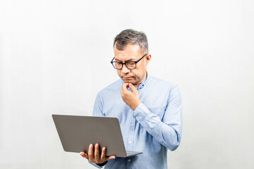 Businessman thinking and analyzing business growth from a laptop computer. Man holding notebook computer and use it. Concept for finance, business operations, real estate, technology, white background