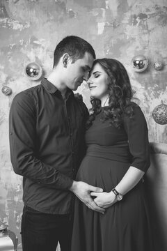 Image of husband standing and holding belly of pregnant wife hands. Woman, girl and loving handsome man hugging tummy at home. Loving Couple. Parenthood concept. Baby Shower. Family photo.