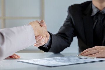 Obraz premium Managers and job applicants shake hands after the job interview, job interviews to find people to work with the company and talent to work with. Concept of recruitment and job interviews.