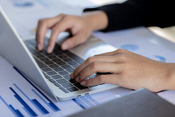 A business man is checking company financial documents and using a laptop to talk to the chief financial officer through a messaging program. Concept of company financial management.