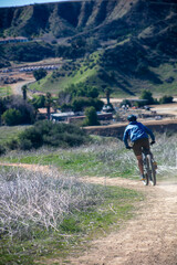 A Man Riding Full Tilt Down a California Mountain Trail on a Bike