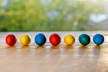 Colorful easter eggs lined up on a wooden table. Selective focus