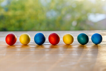 Naklejka premium Colorful easter eggs lined up on a wooden table. Selective focus