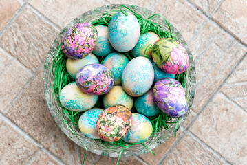 Artistically decorated Colorful easter eggs with collage in a glass bowl. Top View