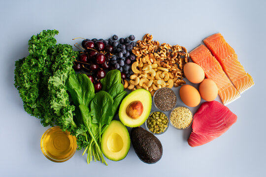 Overhead View of Fresh Omega-3 Rich Foods: A variety of healthy foods like fish, nuts, seeds, fruit, vegetables, and oil rich in omega-3 nutrients