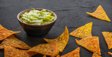 Bowl with guacamole dip and nachos or tortilla chips