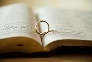 Wedding ring on a bible page.