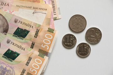 Ukrainian hryvnia and Russian ruble lie on a white background, sanctions against Russia, the...